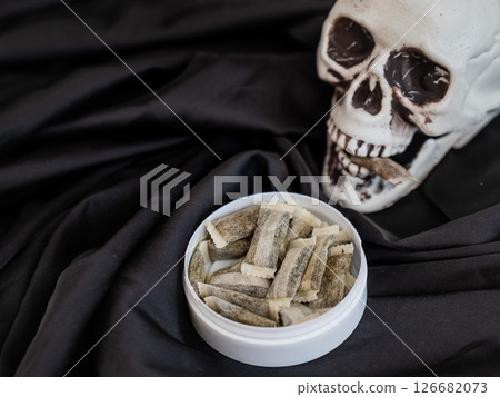 Skull Chewing Tobacco on Black Cloth.  126682073