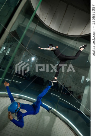A man and a woman enjoy flying together in a wind tunnel. Free fall simulator A man and a woman enjoy flying together in a wind tunnel. Free fall simulator 126682087