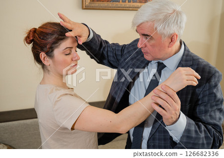 Elderly male hypnotherapist with a female patient. An alternative way to heal mental health Elderly male hypnotherapist with a female patient. An alternative way to heal mental health 126682336