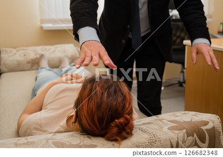 Elderly male hypnotherapist with a female patient. An alternative way to heal mental health Elderly male hypnotherapist with a female patient. An alternative way to heal mental health 126682348