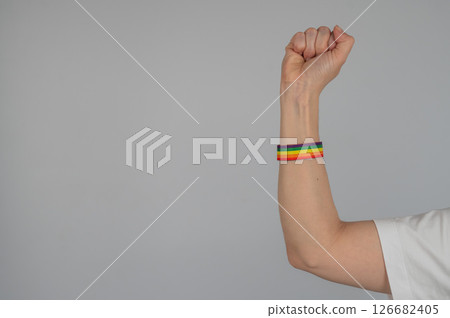 Woman's fist with rainbow bracelet.  126682405