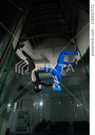 A man and a woman enjoy flying together in a wind tunnel. Free fall simulator 126682572
