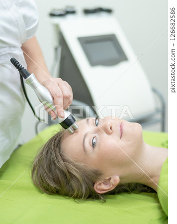 Caucasian woman undergoing radio wave RF lifting procedure in beauty salon.  126682586