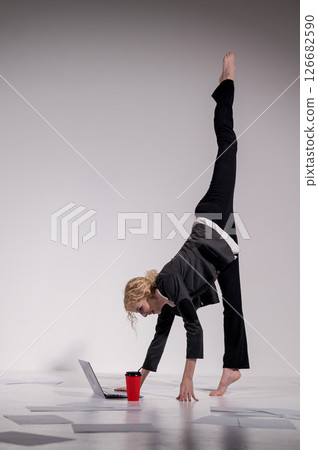 Barefoot ballerina dancing in business suit on white background.  126682590