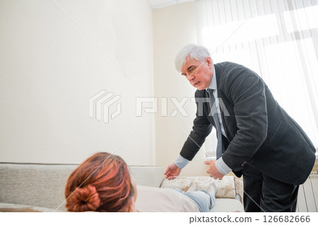 Elderly male hypnotherapist with a female patient. An alternative way to heal mental health Elderly male hypnotherapist with a female patient. An alternative way to heal mental health 126682666
