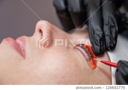 Caucasian woman undergoing eyelash lamination procedure. Caucasian woman undergoing eyelash lamination procedure. 126682770