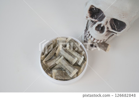 Skull Chewing Tobacco on a White Table. Skull Chewing Tobacco on a White Table. 126682848