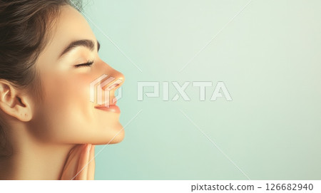 Profile of a beautiful woman breathing with closed eyes, touching her chin with her hand, showing the results of rhinoplasty surgery, a concept of cosmetology and beauty Profile of a beautiful woman breathing with closed eyes, touching her chin with her hand, showing the results of rhinoplasty surgery, a concept of cosmetology and beauty 126682940