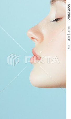 Profile of beautiful woman breathing with closed eyes, showing perfect nose, lips and chin against a blue background, ideal for beauty and cosmetology concepts 126683099