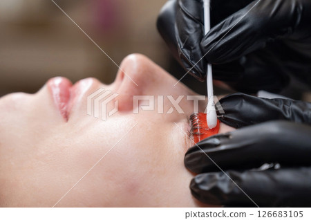 Caucasian woman undergoing eyelash lamination procedure.  126683105
