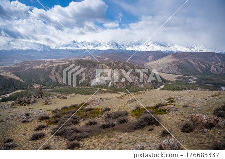 Panoramic view of Kurai Steppe with snow-covered North Chuysky Ridge in Altai Russia. Wide Siberian mountain landscape showcasing winter terrain and open plains. 126683337