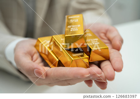 Asian woman holding gold bar in finance business. Asian woman holding gold bar in finance business. 126683397