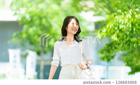 Smiling woman/businesswoman walking outdoors 126683808