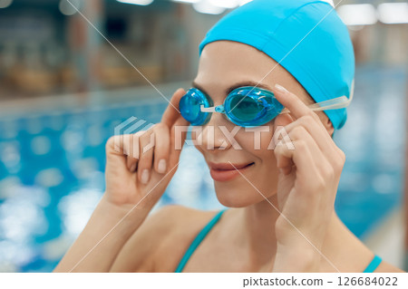 Waist up of young caucasian woman in swimwear in the pool 126684022