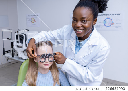 African american female optometrist checking vision of a small patient 126684090