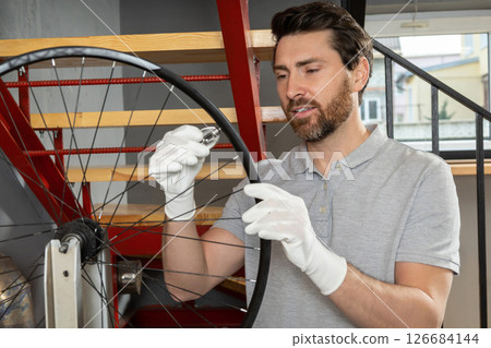Mechanic in white gloves adjusting wheel Mechanic in white gloves adjusting wheel 126684144
