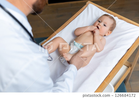Cute little baby boy in diaper looking sweet and happy in the doctors office Cute little baby boy in diaper looking sweet and happy in the doctors office 126684172