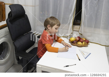 Young student doing homework at home with fruits on the table 126684291