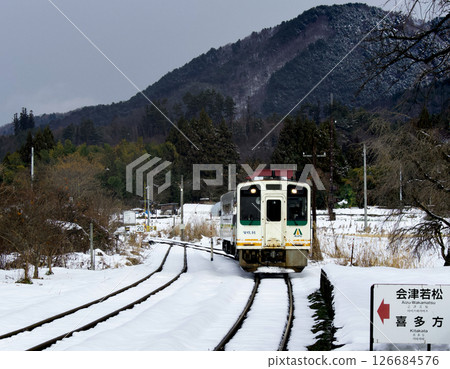 Rural landscape with snow and an approaching train Rural landscape with snow and an approaching train 126684576