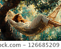 A young woman in light clothing relaxes, half lying in a hammock in the shade of a green garden. A simple life 126685209