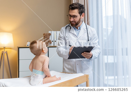 Pediatrician examining a cute little baby boy in his office Pediatrician examining a cute little baby boy in his office 126685265