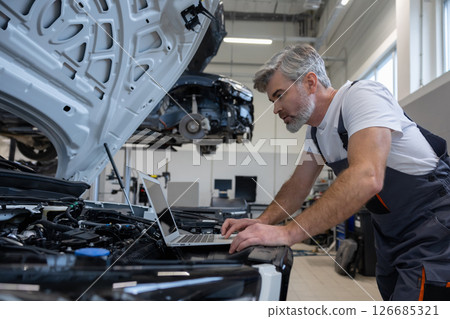 Mechanic with laptop in auto repair workshop 126685321