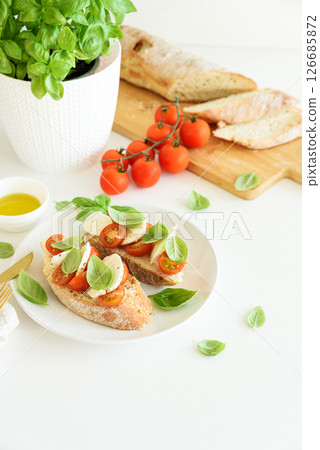 Fresh bruschetta with mozzarella, cherry tomatoes, and basil. Fresh bruschetta with mozzarella, cherry tomatoes, and basil. 126685872