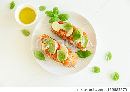 Fresh bruschetta with mozzarella, cherry tomatoes, and basil. Fresh bruschetta with mozzarella, cherry tomatoes, and basil. 126685873