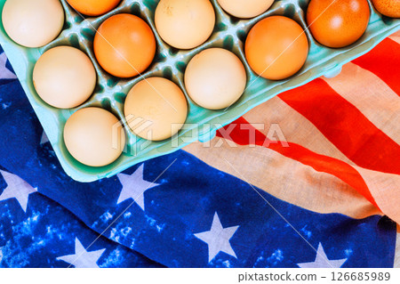 Fresh eggs in pastel blue carton positioned on vintage American flag fabric. Eggs display showcasing farm fresh quality Fresh eggs in pastel blue carton positioned on vintage American flag fabric. Eggs display showcasing farm fresh quality 126685989