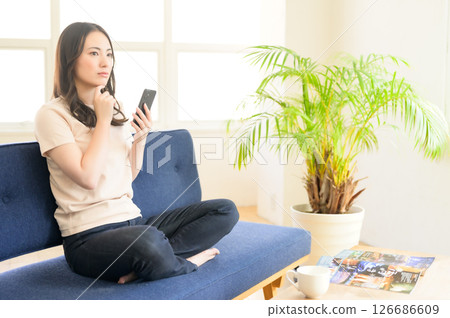 坐沙發和操作智能手機的婦女 126686609