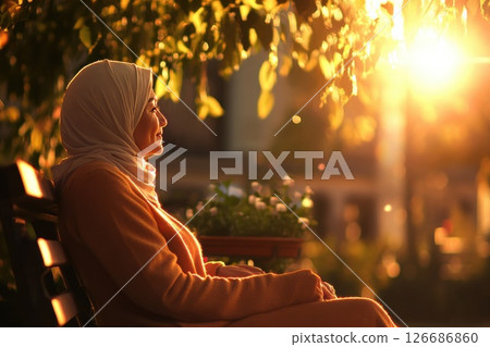 Middle aged woman enjoying a peaceful moment in a sunlit urban park 126686860