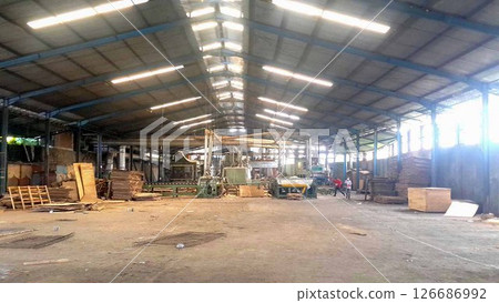 plywood processing plant showcasing Industrial Warehouse Interior with Stacks of Materials and Machinery, warehouse featuring industrial equipment, materials, and wooden pallets 126686992