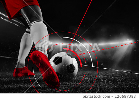 Close-up of red cleats striking soccer ball under stadium lights with radial red tracking lines. Conceptual artwork 126687388