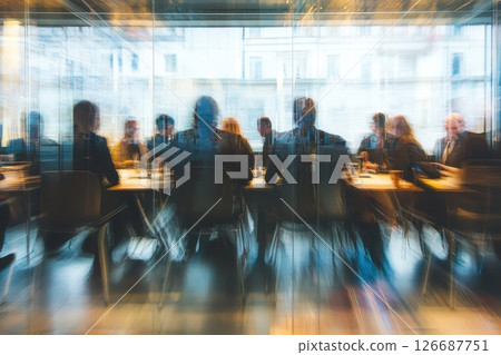 A blurry image of a group of people sitting at a table in a restaurant 126687751