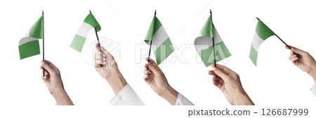 The Nigeria flag in hand in different angles on a white background The Nigeria flag in hand in different angles on a white background 126687999