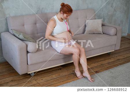A pregnant woman listens to her baby's pulse using a phonendoscope. 126688912
