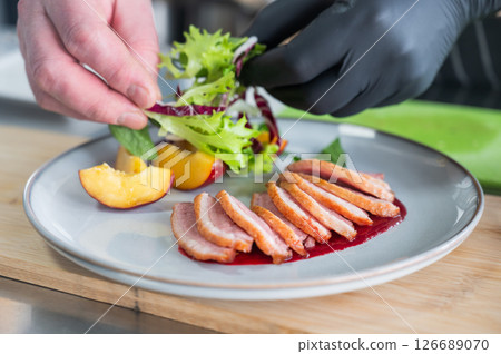 The chef serves roast duck.  126689070