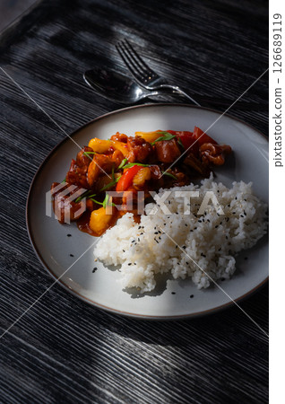 Pork in sweet and sour sauce with boiled rice on a plate. Pork in sweet and sour sauce with boiled rice on a plate. 126689119