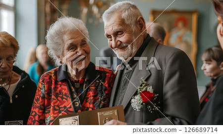 An elderly Chernobyl survivor couple receive a prestigious pension award, beaming with pride and joy. 126689714
