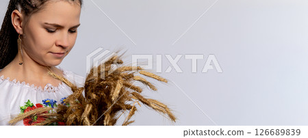 Embracing Traditional Attire and Displaying a Wheat Bundle in a Joyous Cultural Celebration Embracing Traditional Attire and Displaying a Wheat Bundle in a Joyous Cultural Celebration 126689839