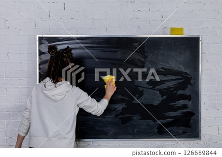 Cleaning a blackboard with a sponge is essential for effective education in classrooms 126689844