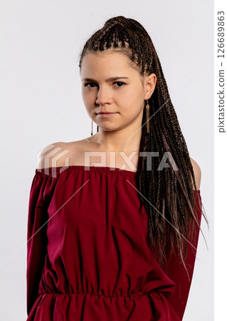 An Elegant Young Woman Dressed in a Beautiful Burgundy Dress, Sporting Braided Hair Style An Elegant Young Woman Dressed in a Beautiful Burgundy Dress, Sporting Braided Hair Style 126689863