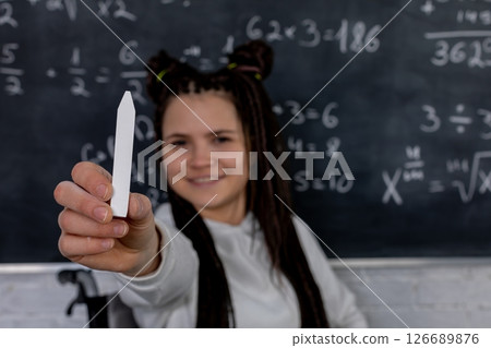 A Young Student Smiling Cheerfully with a Marker in Front of Complicated Math Equations 126689876