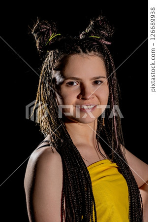 A cheerful young woman in a bright yellow outfit with braided hair, radiating charm and confidence 126689938