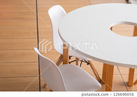 White round table and chairs in children's room with wooden floor 126690058