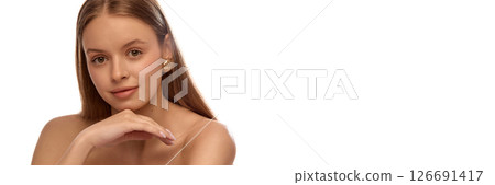 Banner. Charming woman with golden earrings resting hand under chin, looking relaxed and smiling gently, smooth hair and radiant face lighted evenly. Copy space 126691417
