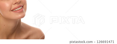 Banner. Close-up of smiling young woman's lower face with visible clean white teeth, smooth lips and glowing skin against white background Banner. Close-up of smiling young woman's lower face with visible clean white teeth, smooth lips and glowing skin against white background 126691471