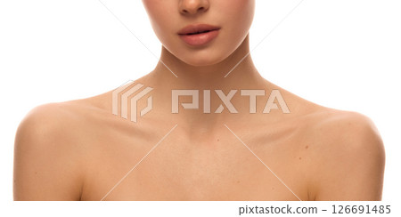 Cropped photo of young woman's bare shoulders and lower face with perfect skin texture and collarbones against white studio background. Concept of beauty and sensuality Cropped photo of young woman's bare shoulders and lower face with perfect skin texture and collarbones against white studio background. Concept of beauty and sensuality 126691485