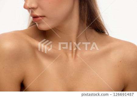 Model's bare shoulders and neck in side profile with soft shadows and even skin tone, lips slightly parted and delicate pose against white background Model's bare shoulders and neck in side profile with soft shadows and even skin tone, lips slightly parted and delicate pose against white background 126691487