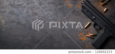 Handgun and casings on textured surface Handgun and casings on textured surface 126692223